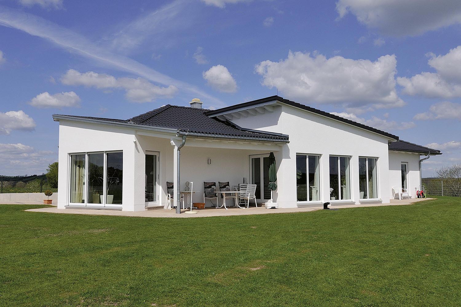 Modernes Einfamilienhaus von Gerhäuser Bau - Baufirma für Massivbau in Mittelfranken mit großzügiger Terrasse und Rasenfläche.